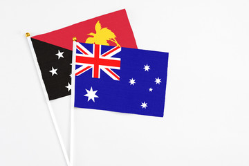 Fototapeta premium Australia and Papua New Guinea stick flags on white background. High quality fabric, miniature national flag. Peaceful global concept.White floor for copy space.