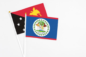 Belize and Papua New Guinea stick flags on white background. High quality fabric, miniature national flag. Peaceful global concept.White floor for copy space.