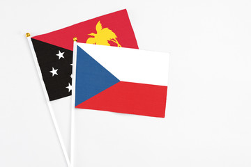 Czech Republic and Papua New Guinea stick flags on white background. High quality fabric, miniature national flag. Peaceful global concept.White floor for copy space.