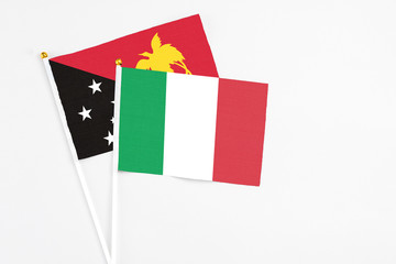 Italy and Papua New Guinea stick flags on white background. High quality fabric, miniature national flag. Peaceful global concept.White floor for copy space.