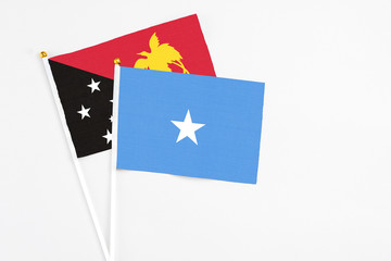 Somalia and Papua New Guinea stick flags on white background. High quality fabric, miniature national flag. Peaceful global concept.White floor for copy space.