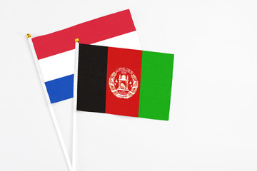 Afghanistan and Paraguay stick flags on white background. High quality fabric, miniature national flag. Peaceful global concept.White floor for copy space.