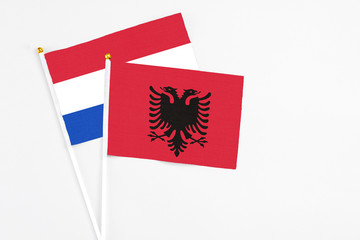 Albania and Paraguay stick flags on white background. High quality fabric, miniature national flag. Peaceful global concept.White floor for copy space.