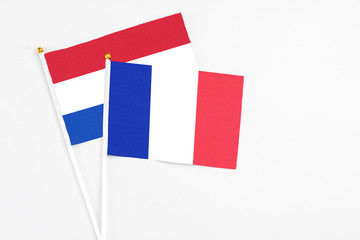 France and Paraguay stick flags on white background. High quality fabric, miniature national flag. Peaceful global concept.White floor for copy space.