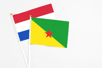 French Guiana and Paraguay stick flags on white background. High quality fabric, miniature national flag. Peaceful global concept.White floor for copy space.