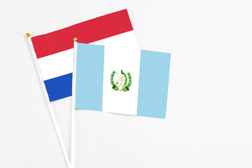 Guatemala and Paraguay stick flags on white background. High quality fabric, miniature national flag. Peaceful global concept.White floor for copy space.