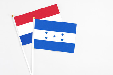 Honduras and Paraguay stick flags on white background. High quality fabric, miniature national flag. Peaceful global concept.White floor for copy space.