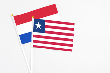Fototapeta premium Liberia and Paraguay stick flags on white background. High quality fabric, miniature national flag. Peaceful global concept.White floor for copy space.