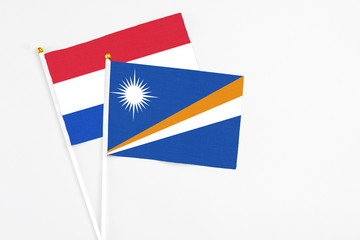 Marshall Islands and Paraguay stick flags on white background. High quality fabric, miniature national flag. Peaceful global concept.White floor for copy space.