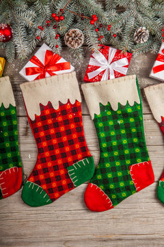 Christmas stocking hanging against wooden wall with gift presents and christmas decorstion