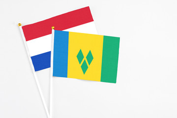 Saint Vincent And The Grenadines and Paraguay stick flags on white background. High quality fabric,...