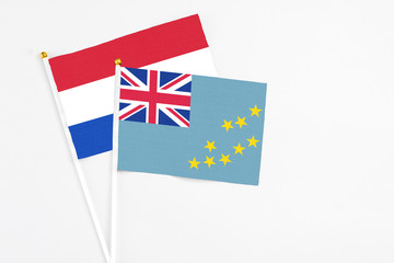 Fototapeta premium Tuvalu and Paraguay stick flags on white background. High quality fabric, miniature national flag. Peaceful global concept.White floor for copy space.