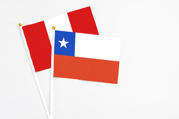 Chile and Peru stick flags on white background. High quality fabric, miniature national flag. Peaceful global concept.White floor for copy space.
