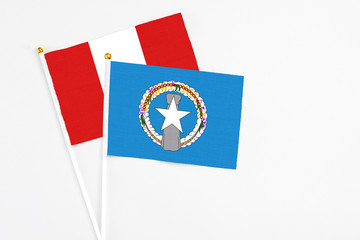 Northern Mariana Islands and Peru stick flags on white background. High quality fabric, miniature national flag. Peaceful global concept.White floor for copy space.