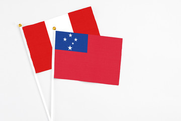 Samoa and Peru stick flags on white background. High quality fabric, miniature national flag. Peaceful global concept.White floor for copy space.
