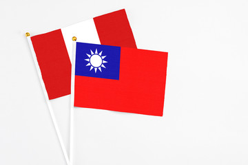 Taiwan and Peru stick flags on white background. High quality fabric, miniature national flag. Peaceful global concept.White floor for copy space.