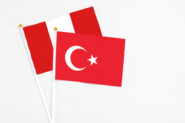 Turkey and Peru stick flags on white background. High quality fabric, miniature national flag. Peaceful global concept.White floor for copy space.