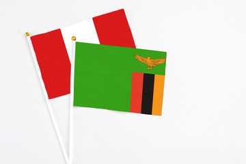 Zambia and Peru stick flags on white background. High quality fabric, miniature national flag. Peaceful global concept.White floor for copy space.