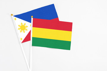 Bolivia and Philippines stick flags on white background. High quality fabric, miniature national flag. Peaceful global concept.White floor for copy space.