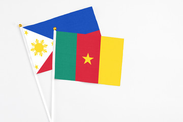 Cameroon and Philippines stick flags on white background. High quality fabric, miniature national flag. Peaceful global concept.White floor for copy space.