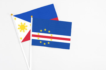 Cape Verde and Philippines stick flags on white background. High quality fabric, miniature national flag. Peaceful global concept.White floor for copy space.