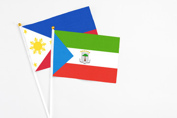 Equatorial Guinea and Philippines stick flags on white background. High quality fabric, miniature national flag. Peaceful global concept.White floor for copy space.