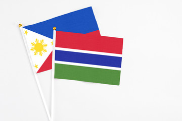 Gambia and Philippines stick flags on white background. High quality fabric, miniature national flag. Peaceful global concept.White floor for copy space.