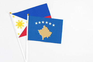 Kosovo and Philippines stick flags on white background. High quality fabric, miniature national flag. Peaceful global concept.White floor for copy space.