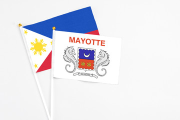 Mayotte and Philippines stick flags on white background. High quality fabric, miniature national flag. Peaceful global concept.White floor for copy space.