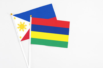 Mauritius and Philippines stick flags on white background. High quality fabric, miniature national flag. Peaceful global concept.White floor for copy space.