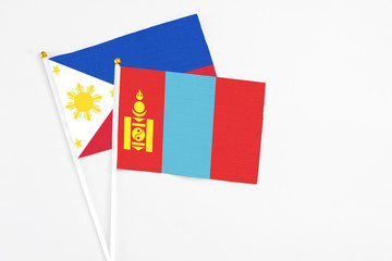Mongolia and Philippines stick flags on white background. High quality fabric, miniature national flag. Peaceful global concept.White floor for copy space.