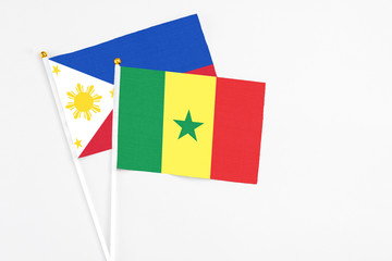 Senegal and Philippines stick flags on white background. High quality fabric, miniature national flag. Peaceful global concept.White floor for copy space.