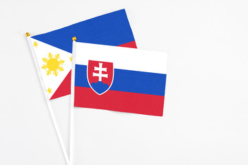 Slovakia and Philippines stick flags on white background. High quality fabric, miniature national flag. Peaceful global concept.White floor for copy space.