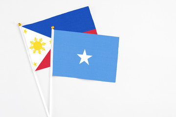 Somalia and Philippines stick flags on white background. High quality fabric, miniature national flag. Peaceful global concept.White floor for copy space.