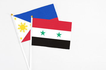 Syria and Philippines stick flags on white background. High quality fabric, miniature national flag. Peaceful global concept.White floor for copy space.