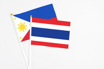 Thailand and Philippines stick flags on white background. High quality fabric, miniature national flag. Peaceful global concept.White floor for copy space.