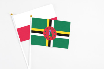 Dominica and Poland stick flags on white background. High quality fabric, miniature national flag. Peaceful global concept.White floor for copy space.