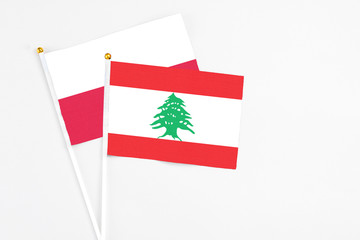 Lebanon and Poland stick flags on white background. High quality fabric, miniature national flag. Peaceful global concept.White floor for copy space.