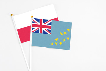 Fototapeta premium Tuvalu and Poland stick flags on white background. High quality fabric, miniature national flag. Peaceful global concept.White floor for copy space.