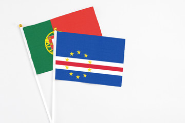 Cape Verde and Portugal stick flags on white background. High quality fabric, miniature national flag. Peaceful global concept.White floor for copy space.