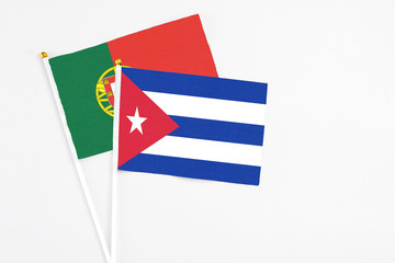 Cuba and Portugal stick flags on white background. High quality fabric, miniature national flag. Peaceful global concept.White floor for copy space.