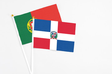 Dominican Republic and Portugal stick flags on white background. High quality fabric, miniature national flag. Peaceful global concept.White floor for copy space.