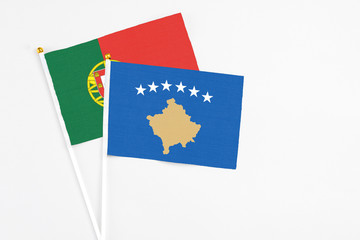 Kosovo and Portugal stick flags on white background. High quality fabric, miniature national flag. Peaceful global concept.White floor for copy space.