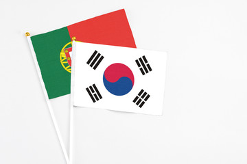 South Korea and Portugal stick flags on white background. High quality fabric, miniature national flag. Peaceful global concept.White floor for copy space.