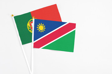 Namibia and Portugal stick flags on white background. High quality fabric, miniature national flag. Peaceful global concept.White floor for copy space.