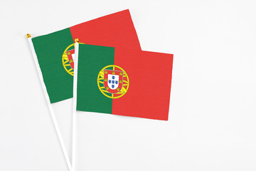 Portugal and Portugal stick flags on white background. High quality fabric, miniature national flag. Peaceful global concept.White floor for copy space.
