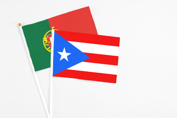 Puerto Rico and Portugal stick flags on white background. High quality fabric, miniature national flag. Peaceful global concept.White floor for copy space.