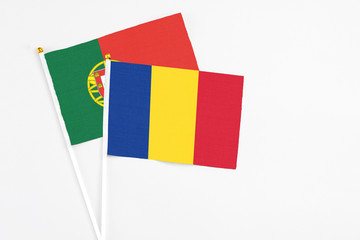 Romania and Portugal stick flags on white background. High quality fabric, miniature national flag. Peaceful global concept.White floor for copy space.