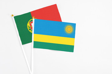 Rwanda and Portugal stick flags on white background. High quality fabric, miniature national flag. Peaceful global concept.White floor for copy space.