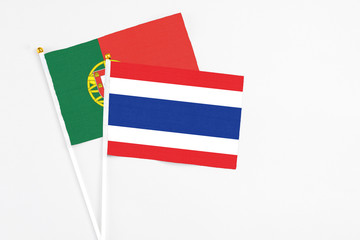 Thailand and Portugal stick flags on white background. High quality fabric, miniature national flag. Peaceful global concept.White floor for copy space.